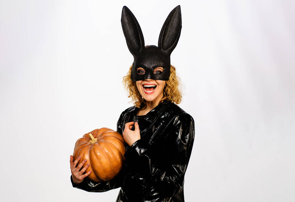 Mujer sonriente con máscara de conejito negro con calabaza. 31 de octubre. Chica sexy en disfraz de Halloween con jack-o-linterna. - Foto, Imagen