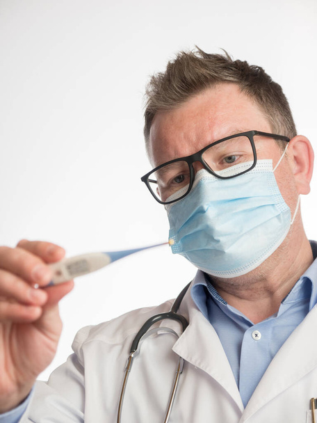 Portrait of a doctor holding a thermometer to check temperature - Foto, Bild