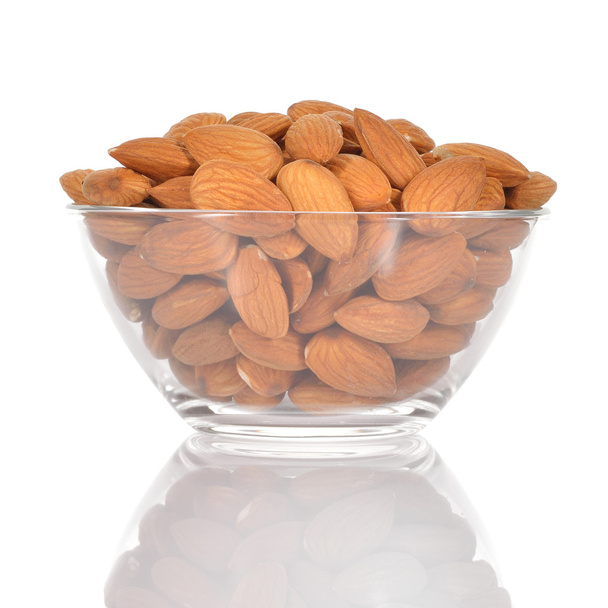 Almonds in a glass bowl on white background. - Photo, Image