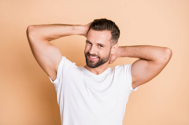 Photo of young handsome brown hair masculine man happy positive smile enjoy hair care shampoo isolated over beige color background - Fotoğraf, Görsel