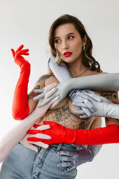 Sexy woman with tattoos wearing gloves on white background - Fotografie, Obrázek