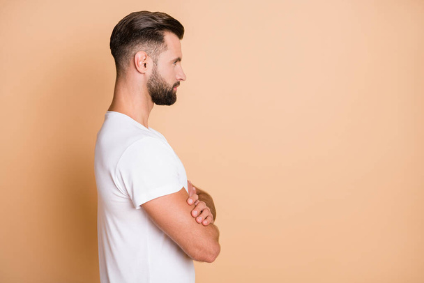 Profile side view portrait of serious virile guy folded arms copy empty blank place space isolated over beige pastel color background - Foto, Bild