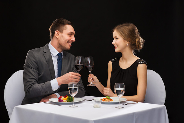 smiling couple eating main course at restaurant - 写真・画像