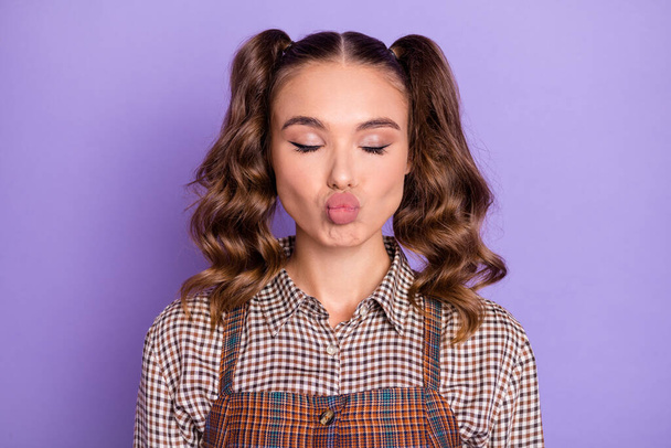 Portrait of optimistic funky young girl blow kiss closed eyes wear brown shirt isolated on lilac color background - Photo, image
