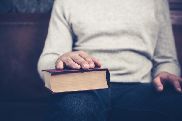 Man sitting with his hand on a book - Foto, immagini