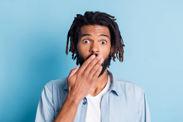 Close-up portrait of nice funny puzzled guy closing mouth oops isolated over vibrant blue color background - Foto, immagini