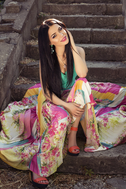 beautiful elegant woman in colorful dress posing at park - Foto, imagen