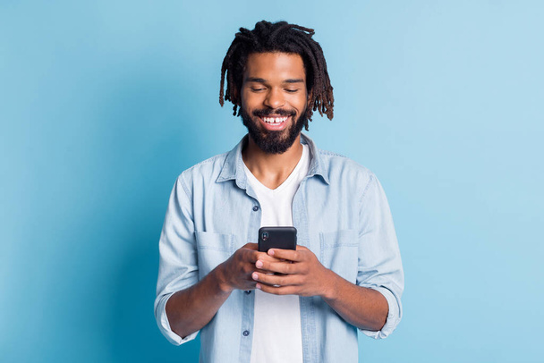 Portrait of attractive cheerful focused guy using device chatting free time isolated over bright blue color background - Zdjęcie, obraz