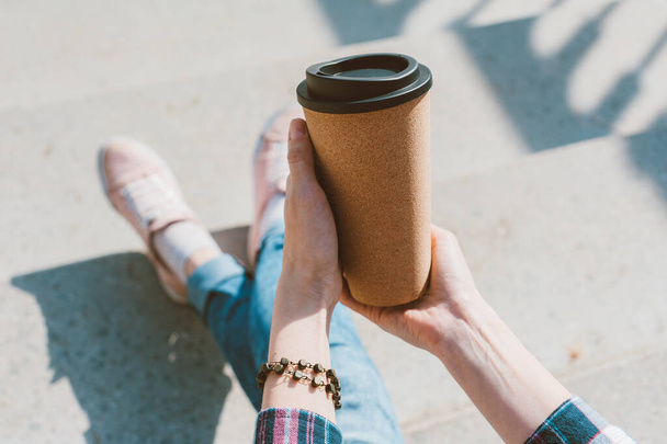 The girl holds a thermo mug with coffee in her hand - Photo, image