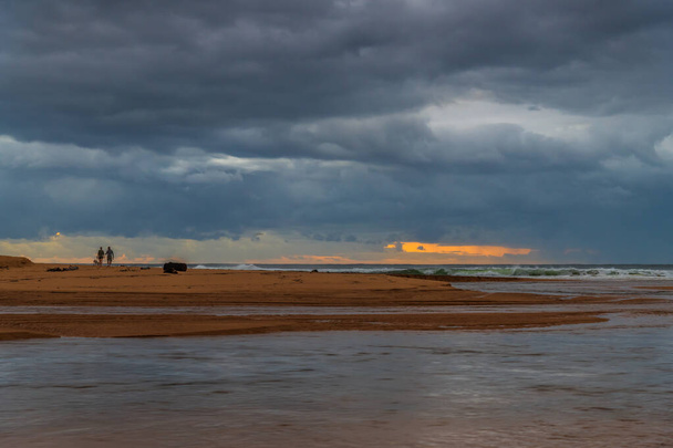 Amanecer nublado junto al mar con la laguna abierta al mar en la laguna de Avoca en la costa central, NSW, Australia. - Foto, imagen