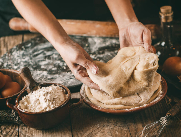Γυναίκα χέρια μαγείρεμα ψωμί με τυρί, αυγά και βότανο σε ρουστίκ ξύλινο φόντο. Σπιτικό υγιεινό φαγητό έννοια, τόνωση - Φωτογραφία, εικόνα