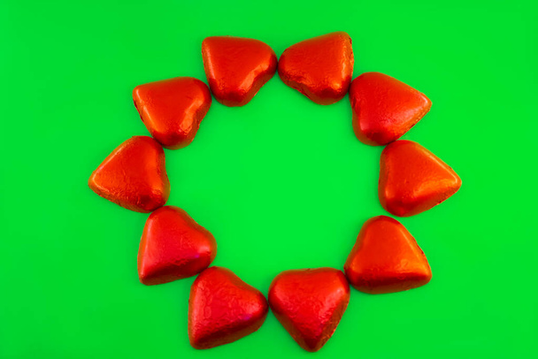 Schokoladenbonbons Herzform auf grünem Hintergrund - Foto, Bild