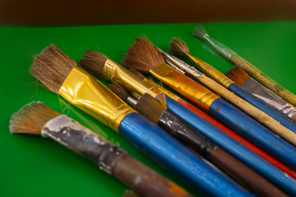 old brushes for paint on a green background - Photo, Image