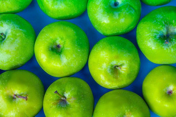 mele verdi su sfondo blu, frutta - Foto, immagini