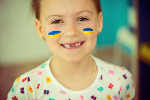 Ukrainian girl with national flag on cheek - Foto, Imagem