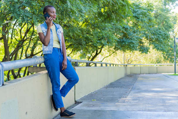 feliz afroamericana joven mujer hablando con el teléfono celular en la ciudad - Foto, Imagen