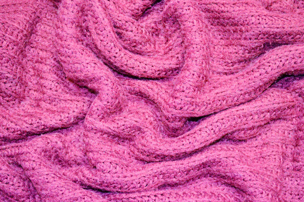Pinkfarbenes Strickmuster als Hintergrund. Nahaufnahme auf rosa Strickstoff Textur auf Stoff. zerknitterte Textur - Foto, Bild