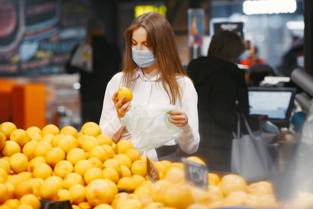 Woman in a medical mask in a supermarket - Foto, imagen
