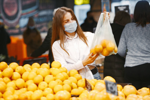 Woman in a medical mask in a supermarket - Photo, Image