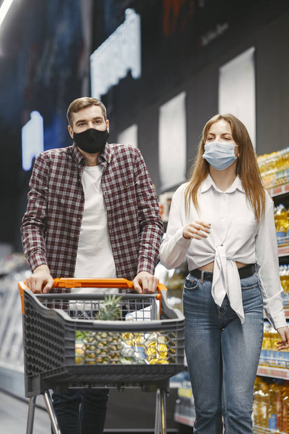 People in a medical mask in a supermarket - Фото, изображение