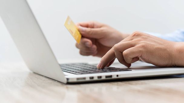 Plastová kreditní karta v ruce a použití notebooku pro nákup přes internet. Online nákupní nápady - Fotografie, Obrázek