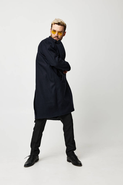 chico guapo en un pantalón de chaqueta sobre un fondo claro en pleno crecimiento y zapatos de moda - Foto, Imagen