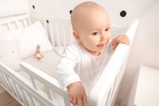 Cute little baby in crib at home - Φωτογραφία, εικόνα