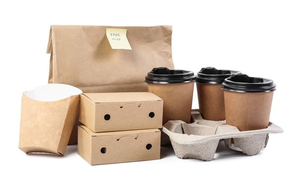 Papiertüte mit Aufkleber TAKE OUT, Boxen für Lebensmittel und Tassen auf weißem Hintergrund - Foto, Bild