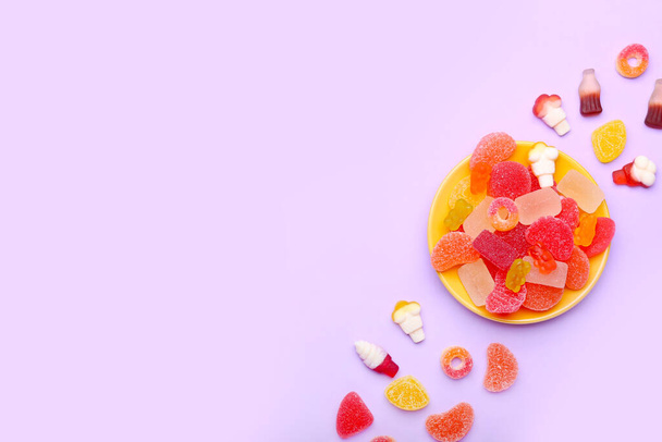 Placa con dulces caramelos de gelatina sobre fondo de color - Foto, Imagen