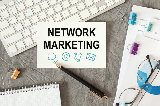 Network Marketing lettering on cards on the office desk with office supplies and documents. - 写真・画像