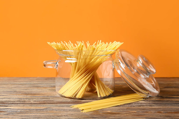 Stylish cooking pot with raw pasta on wooden table - Foto, Imagen