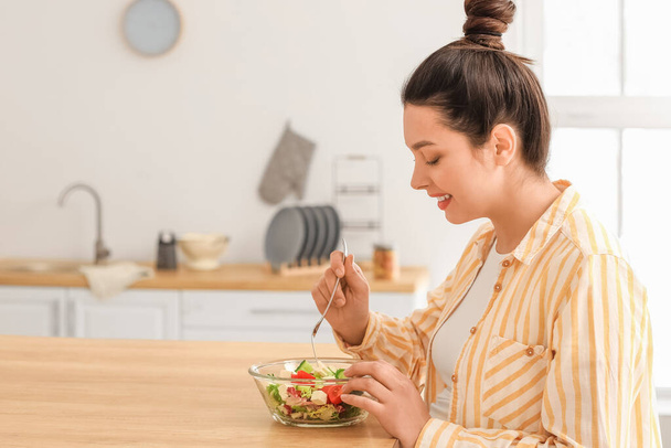 Young pregnant woman eating healthy salad at home - Foto, afbeelding
