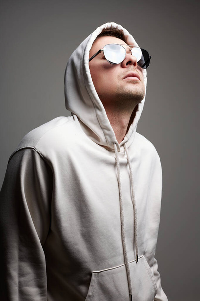 Man in Hood and sunglasses. stylish Boy in a hooded sweatshirt. Male portrait - Photo, Image