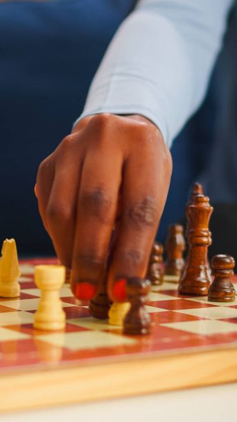 Primo piano della donna nera che muove i pezzi di scacchi a bordo - Foto, immagini