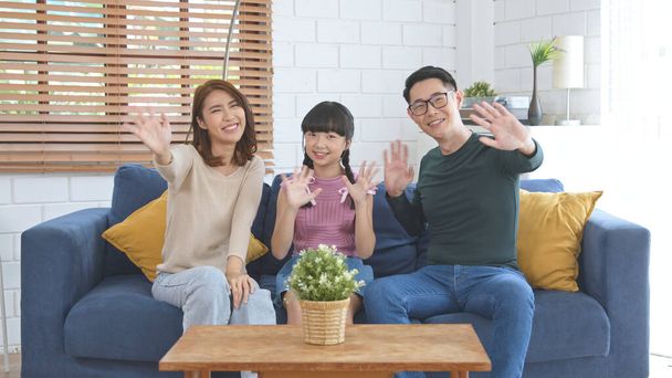 Boldog ázsiai család segítségével tablet video hívás virtuális találkozó együtt kanapén otthon nappali. - Fotó, kép