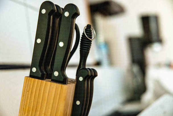 A closeup shot of a knife set with a wooden block in a kitchen - Foto, Bild