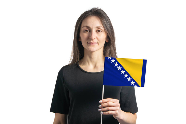 白い背景にボスニアとボスニア・ヘルツェゴビナの旗を掲げた幸せな若い白人女の子. - 写真・画像