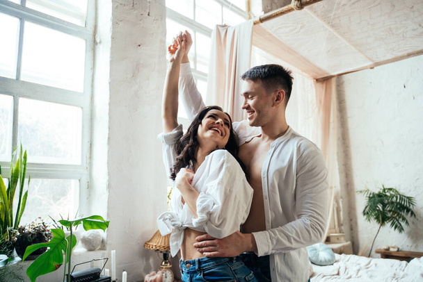 young couple spending time and dancing in their beautiful countryside house - 写真・画像