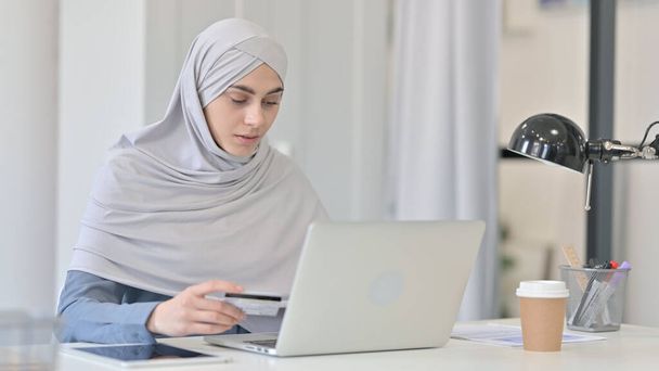 El éxito del pago en línea en el ordenador portátil por la mujer árabe joven  - Foto, imagen