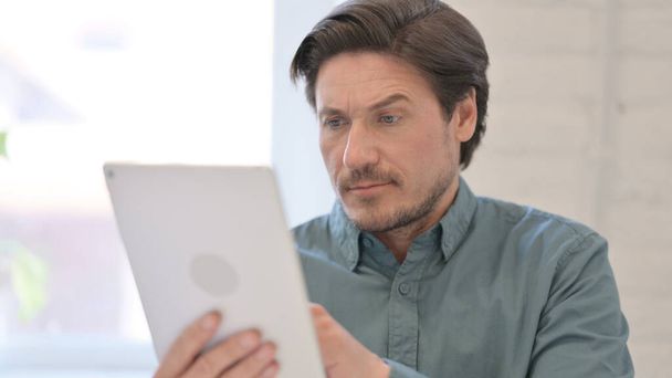 Portrait of Middle Aged Man using Digital Tablet - Fotoğraf, Görsel