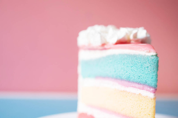 laag regenboog cake op roze achtergrond - Foto, afbeelding