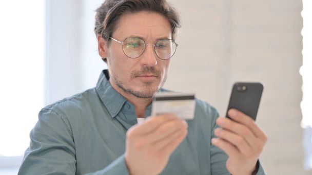 Portrét muže středního věku tvorby on-line nakupování na Smartphone - Fotografie, Obrázek