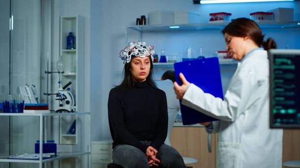 Výzkumník ukazuje na schránku vysvětlující léčbu proti onemocnění mozku - Fotografie, Obrázek