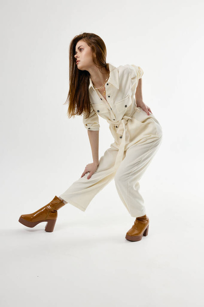 attractive woman in white jumpsuit  bent forward. High quality photo - Φωτογραφία, εικόνα