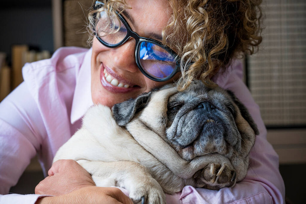 Happy woman hug his dog pug with love and friendship, concept of best friend forever and animal owner enjoying time at home  - Фото, зображення
