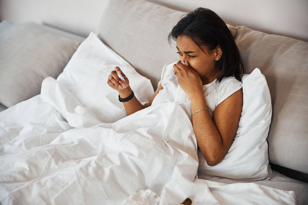 Jeune femme avec grippe vérifiant la température corporelle à la maison - Photo, image