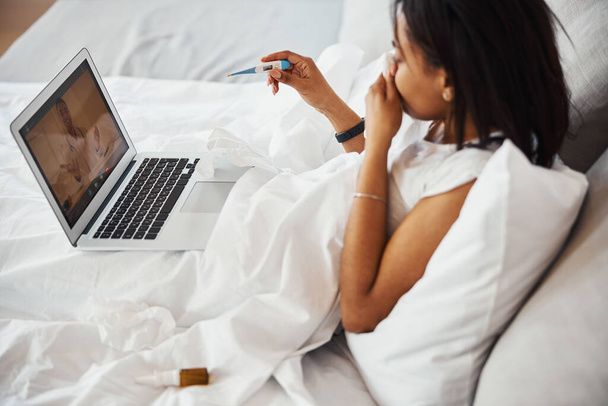 Молодая женщина с гриппом консультируется с врачом онлайн - Фото, изображение