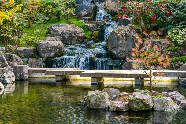 LONDON, UK - APRIL 11, 2021: Opened in 1991 Kyoto Garden in Holland Park with colourful plants, shrubs and water features was a gift from the Chamber of Commerce of Kyoto to British people - 写真・画像