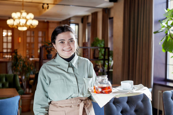Waitress in apron with tray standing in cafe - Zdjęcie, obraz