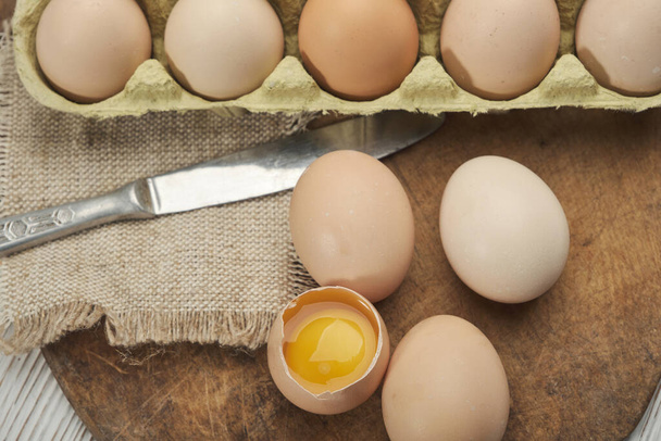 Ahşap arka planda yumurta kutusundaki çiğ tavuk yumurtalarının yakın plan görüntüsü. Yumurta kutusundaki çiğ tavuk yumurtaları sağlıklı ve yüksek protein için organik gıdalar. . - Fotoğraf, Görsel
